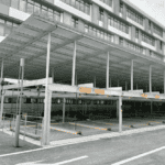 A multi - level prefab steel garage parking structure in an urban area.