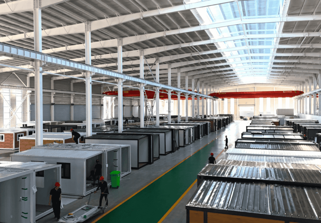 A large factory with rows of modular container houses under construction, showcasing a well-organized production process.