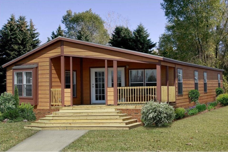 Modern manufactured home with wooden exterior, front porch, and landscaped yard