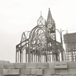 A partially constructed Prefab Steel Church Building with a skeletal steel frame, featuring an arched design and a clock tower in progress.