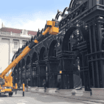 A Prefab Steel Church Building under construction, displaying its intricate black steel archways and part of the main structure adjacent to classic architecture.