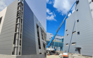 Construction site with a lift installing sandwich panels on a building's exterior.