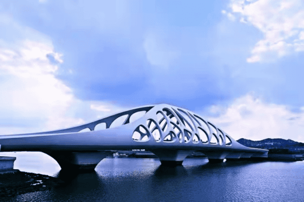 A futuristic white bridge with an intricate shell-like design spanning over a calm river.