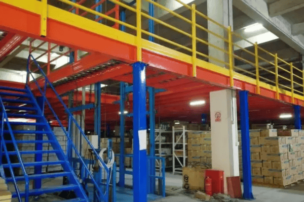 A brightly colored mezzanine structure with red, blue, and yellow beams inside a logistics center.