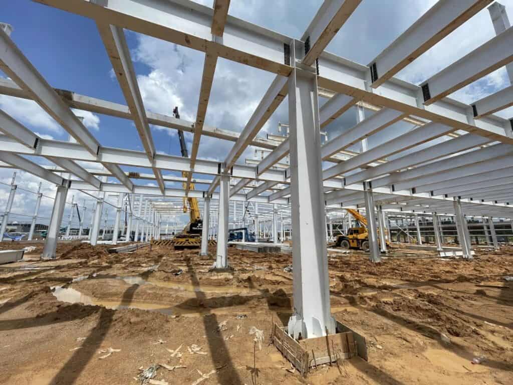 Construction site view of a steel structure bracing system under erection.