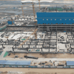 Aerial view of a Steel Structure Multi-Storey Building under construction, with cranes and partially erected steel frames on a large site.