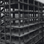 An aerial view of a multi-story Steel Structure Office Building under construction, showing its skeletal steel framework and surrounding area.