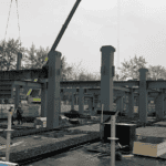 Construction site of a Steel Structure School Building with steel beams and columns laid out, and various construction materials scattered around.