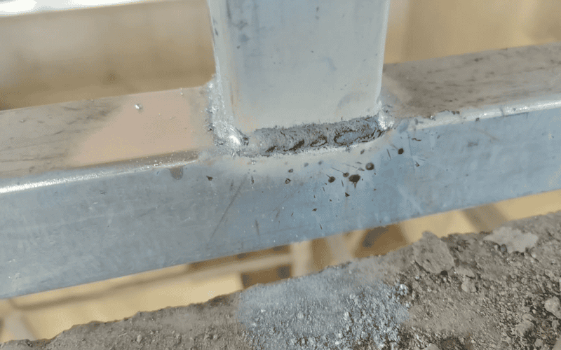 Close-up view of a welded steel joint, showcasing precise fabrication on a construction site.