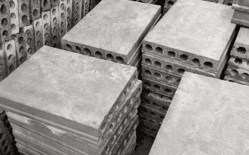 Concrete hollow-core slabs stacked on a construction site, ready for installation."