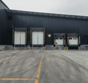 A cold storage loading dock area with large overhead doors and marked parking spaces.