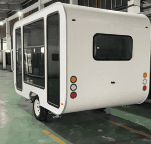 Eine kompakte, weiße mobile Kapsel mit großen Fenstern und Rücklichtern, konzipiert für Tragbarkeit und einfache Bewegung, ideal für verschiedene Anwendungen wie Camping oder mobiles Wohnen.