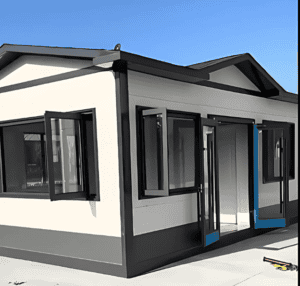 A modular home with a clean, contemporary design, featuring wide windows and a well-constructed entrance with a modern aesthetic, seen in bright daylight.