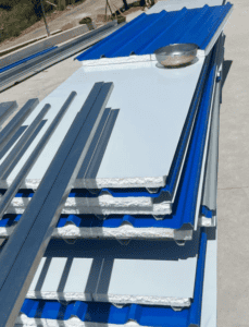 Stacked corrugated metal panels with blue and white surfaces, designed for construction and roofing.