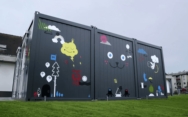 Colorful container-style portable classroom with artistic graffiti designs on the exterior, highlighting creative and functional design.