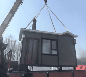 A modular home being lifted with a crane, showcasing the construction process as it is placed onto its foundation.