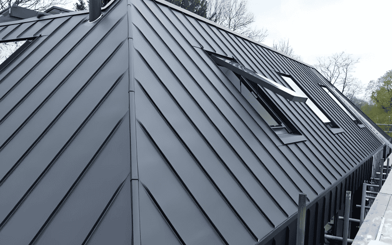 A slanted metal roof with standing seam cladding and skylights