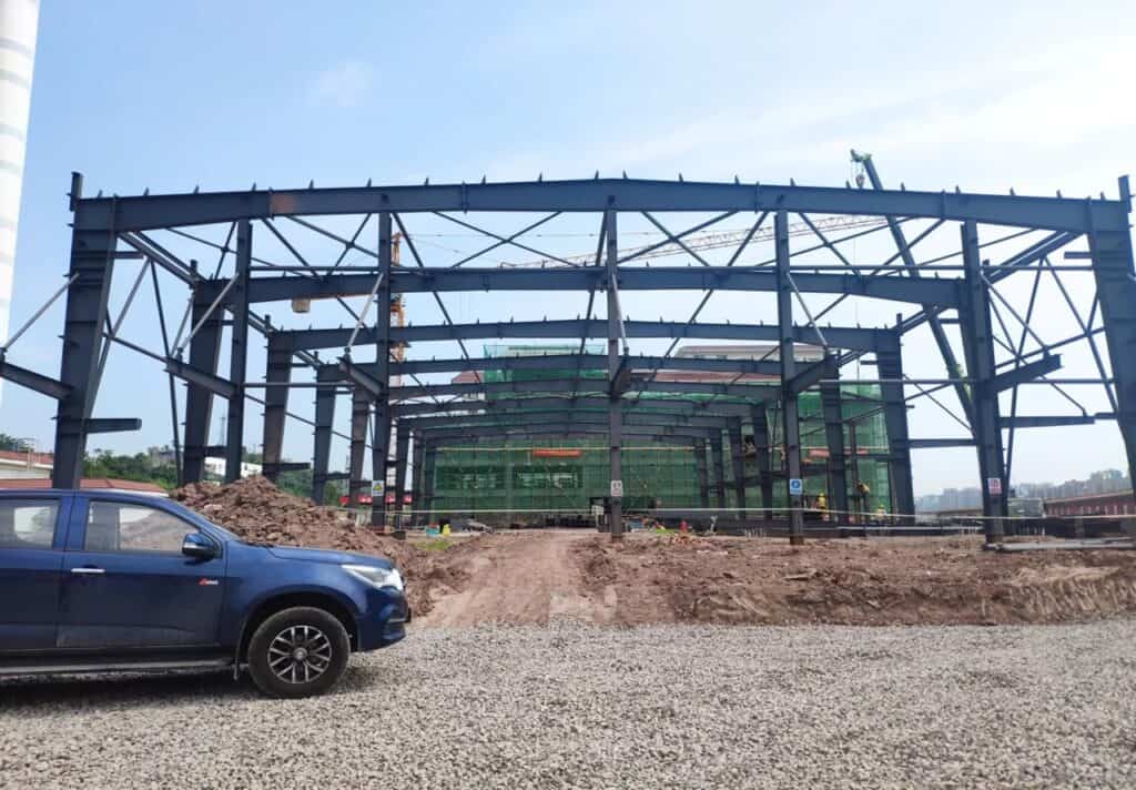 A Peb Structure's Frame System under construction, featuring large black steel frames forming the skeletal structure of the building, indicating strength and stability.