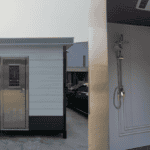 Prefabricated restroom units with a steel door and shower fixtures visible inside, showcasing practical and clean design.