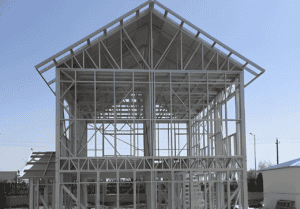 Steel frame of a home from a steel home kit under construction, with a gabled roof structure.