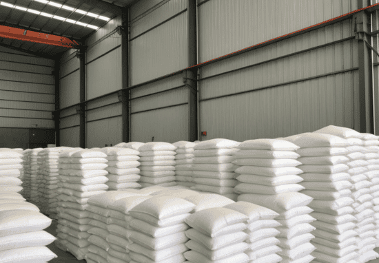 Salt Barn interior with neatly stacked salt bags, showing organized storage within a large steel structure with overhead lighting.