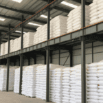 Warehouse with stacked salt bags on shelves, inside a large steel structure, showing an organized storage solution for goods.