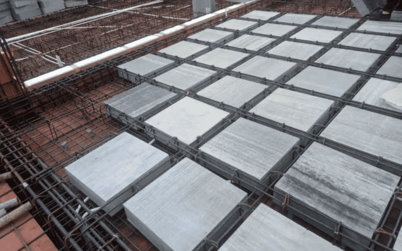 A close-up of a precast concrete slab system with a metal rebar grid, prepared for casting in a construction project.