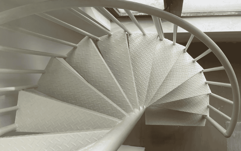 spiral staircase with white, diamond-patterned steps