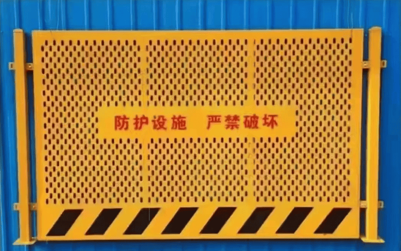 Yellow perforated safety board with black caution stripes and Chinese text indicating protection measures for construction zones.