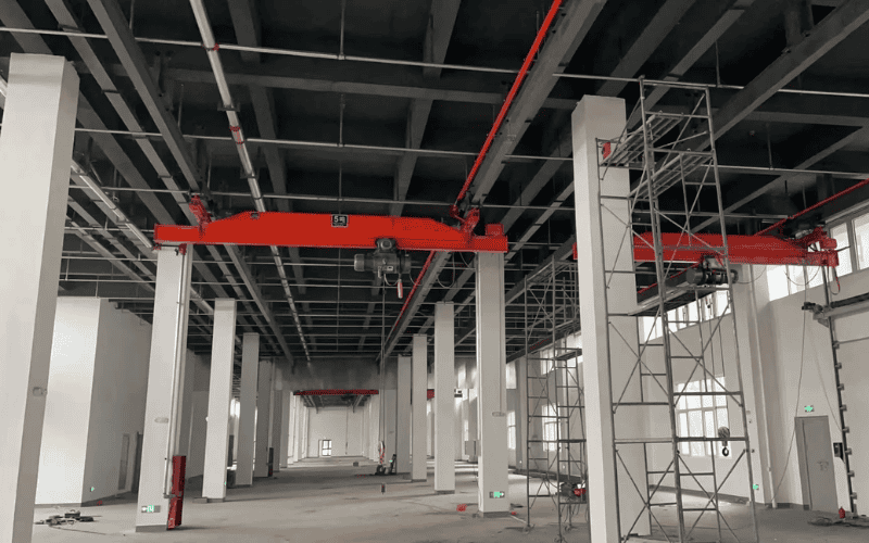 Spacious interior of a steel warehouse with multiple crane beams for industrial operations.